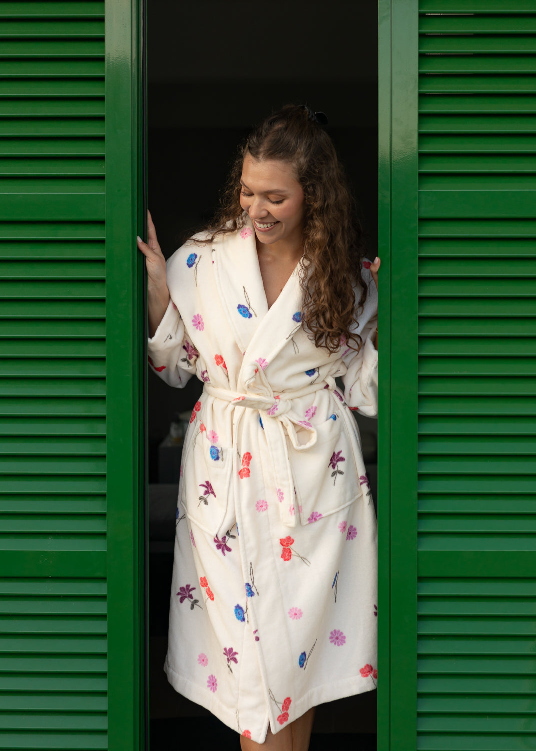Floral cotton bathrobe by Lilja the Label featuring a tie waist, set against green shutters.