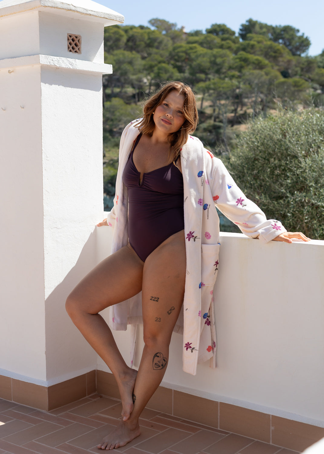 Floral pattern bathrobe from Lilja the Label with a lightweight design and open front worn over a solid-colored swimsuit.